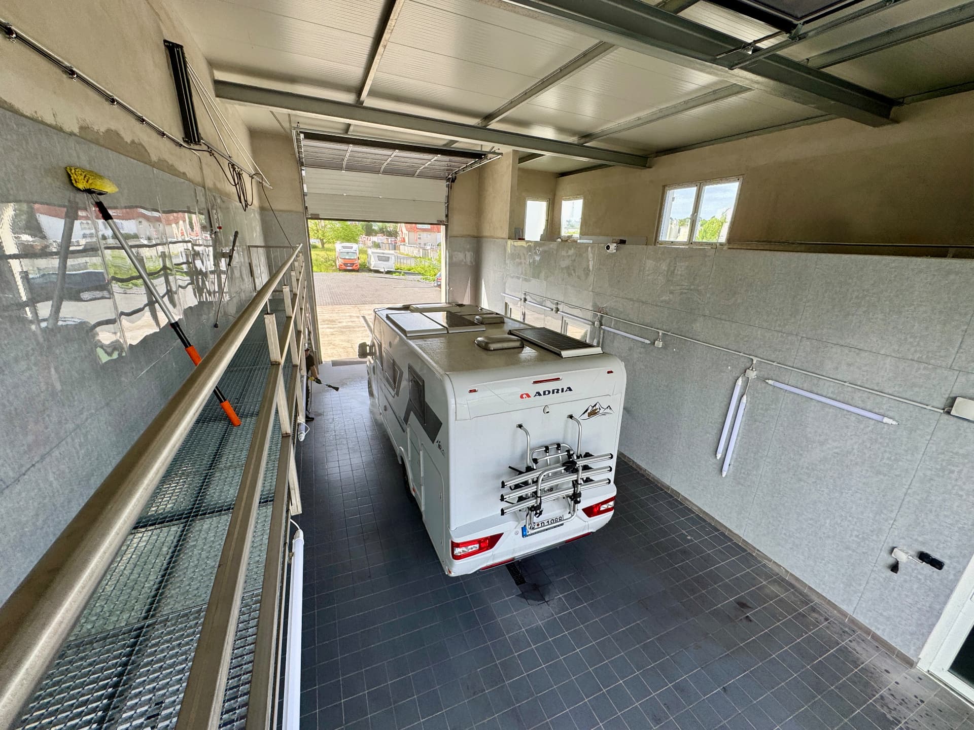 Blick von der Empore auf die Fahrzeugpflege eines Wohnmobils in der Waschhalle