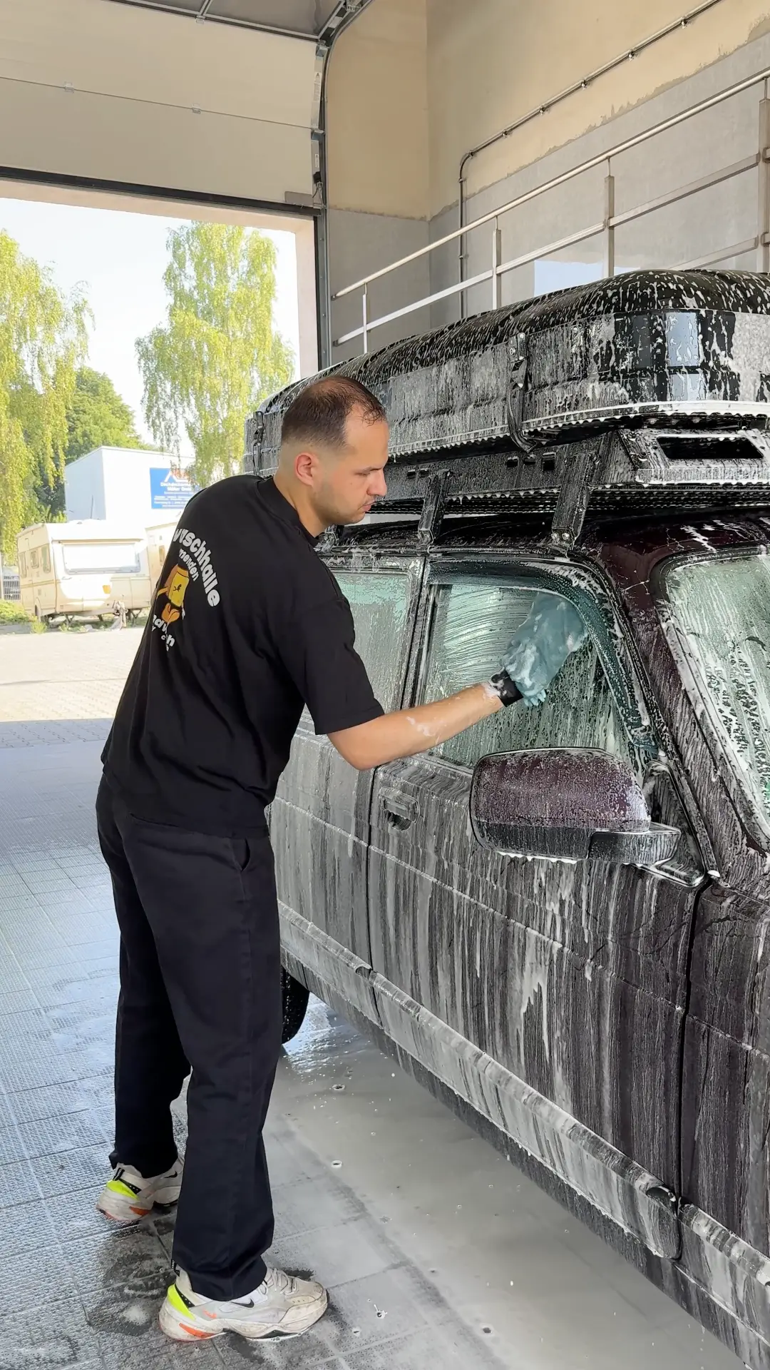 Komplettwäsche: Handwäsche eines SUV mit Dachbox in der Waschhalle